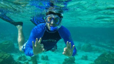 man leaning how to snorkel in belize